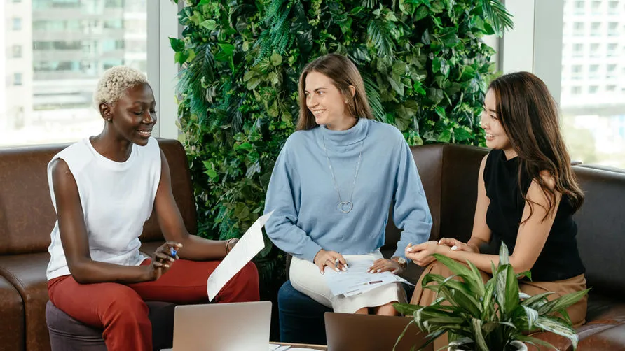 Three colleagues in discussion in front of a living wall